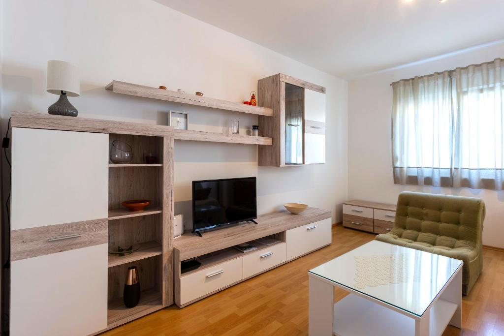 a living room with a television and a table at Apartment Anna with FREE private parking in Pula