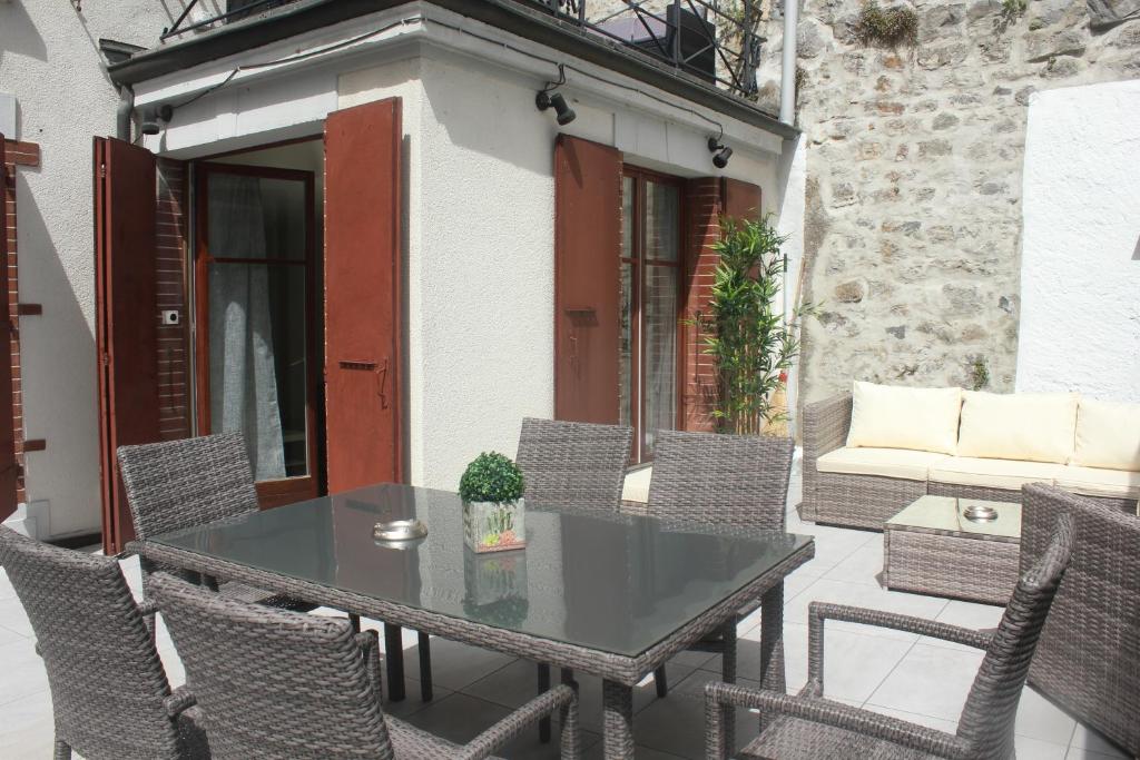 a patio with a table and chairs and a couch at Appartement rénové Montreux 2-8 personnes in Montreux