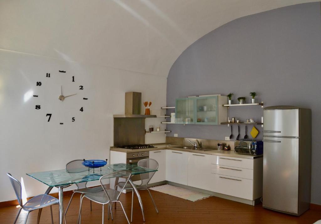 een keuken met een tafel en een roestvrijstalen koelkast bij La mia casa in Biella