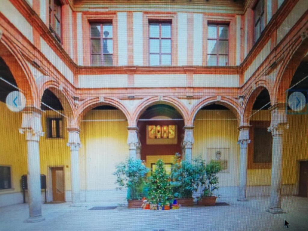een oud gebouw met twee potplanten op de binnenplaats bij Lovely Apartment Piatti Duomo in Milaan