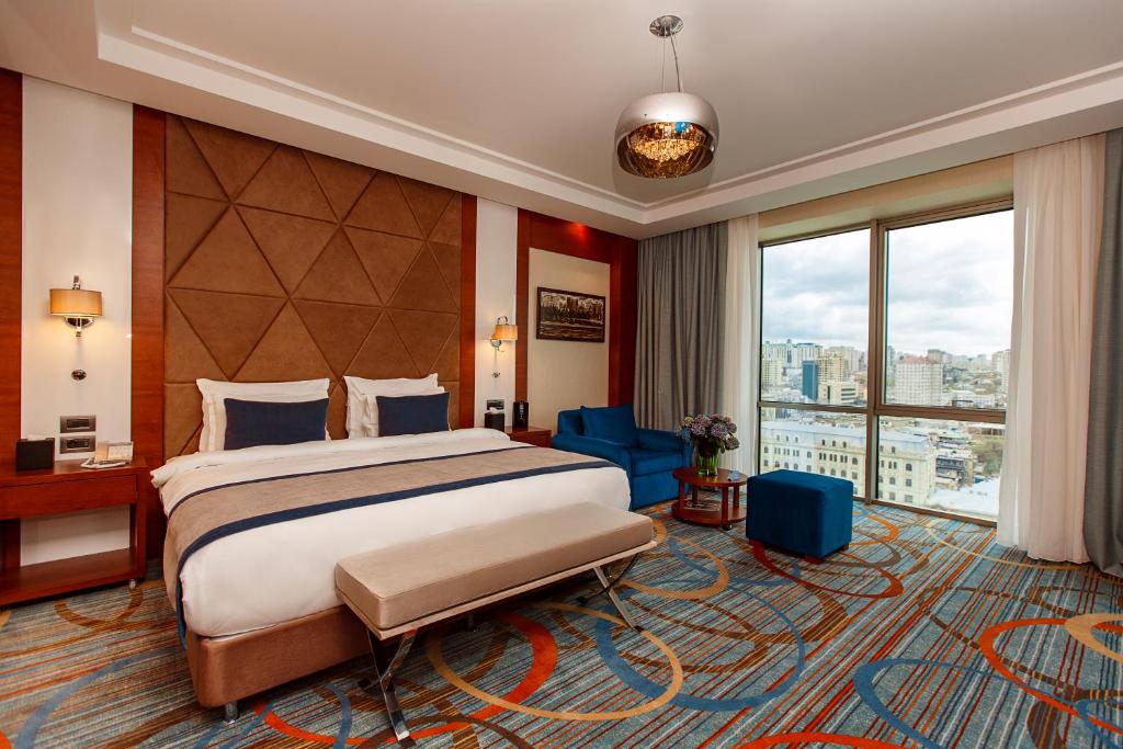 a hotel room with a bed and a large window at Winter Park Hotel Baku in Baku
