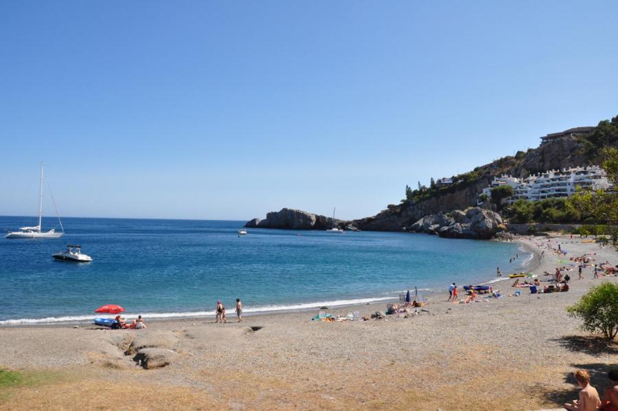 a group of people on a beach near the water at villaquinta in La Herradura