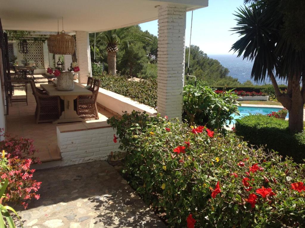 a porch of a house with a table and flowers at villaquinta in La Herradura