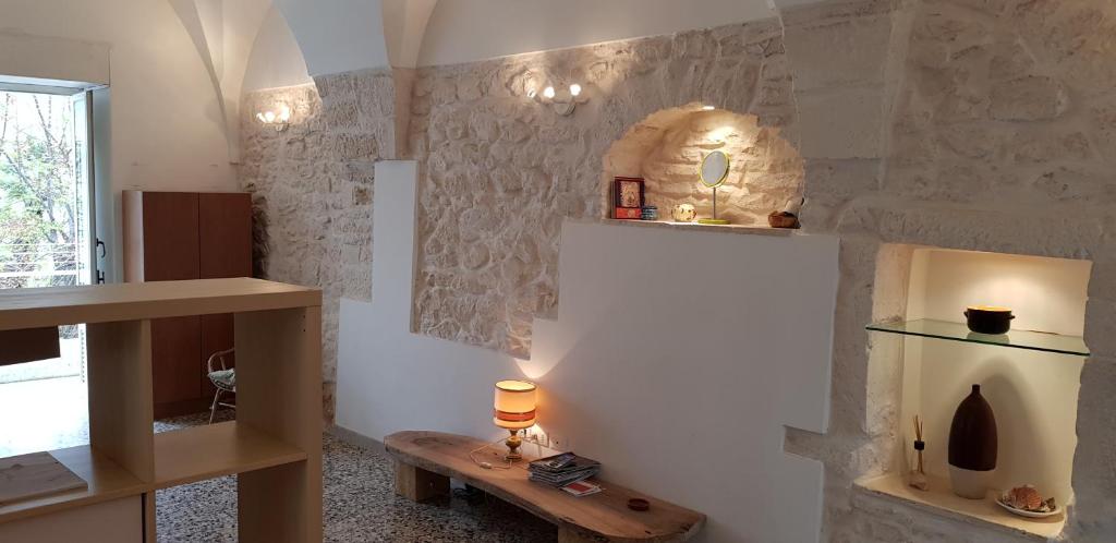 una stanza con un muro in pietra e un tavolo di La Casa Di Zia Caterina a Ceglie Messapica