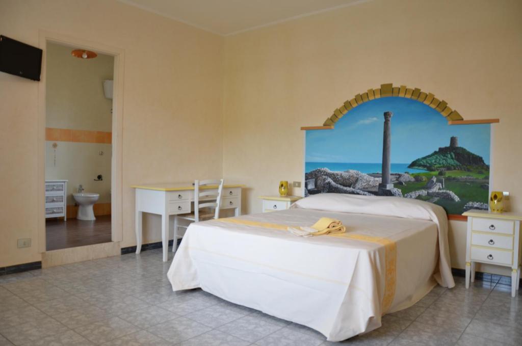 - une chambre avec un lit et une peinture murale dans l'établissement S'Apposentu Affittacamere, à Pula