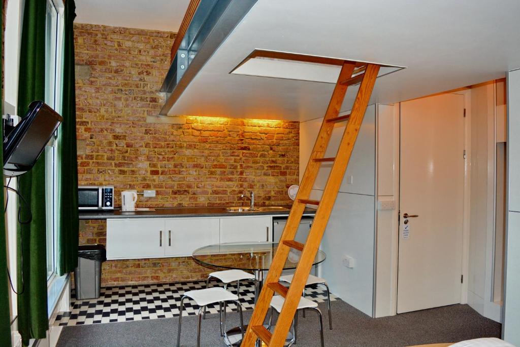 a ladder in a kitchen with a brick wall at Hotel 24 in London