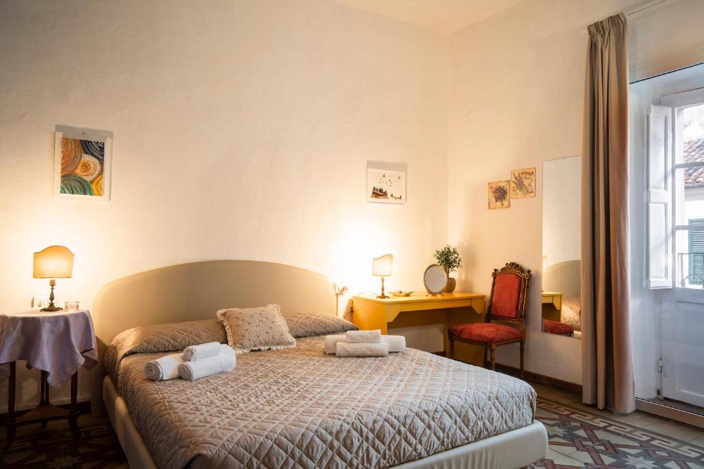 um quarto com uma cama, uma secretária e uma janela em Sardegna Homes Il Glicine em Olbia