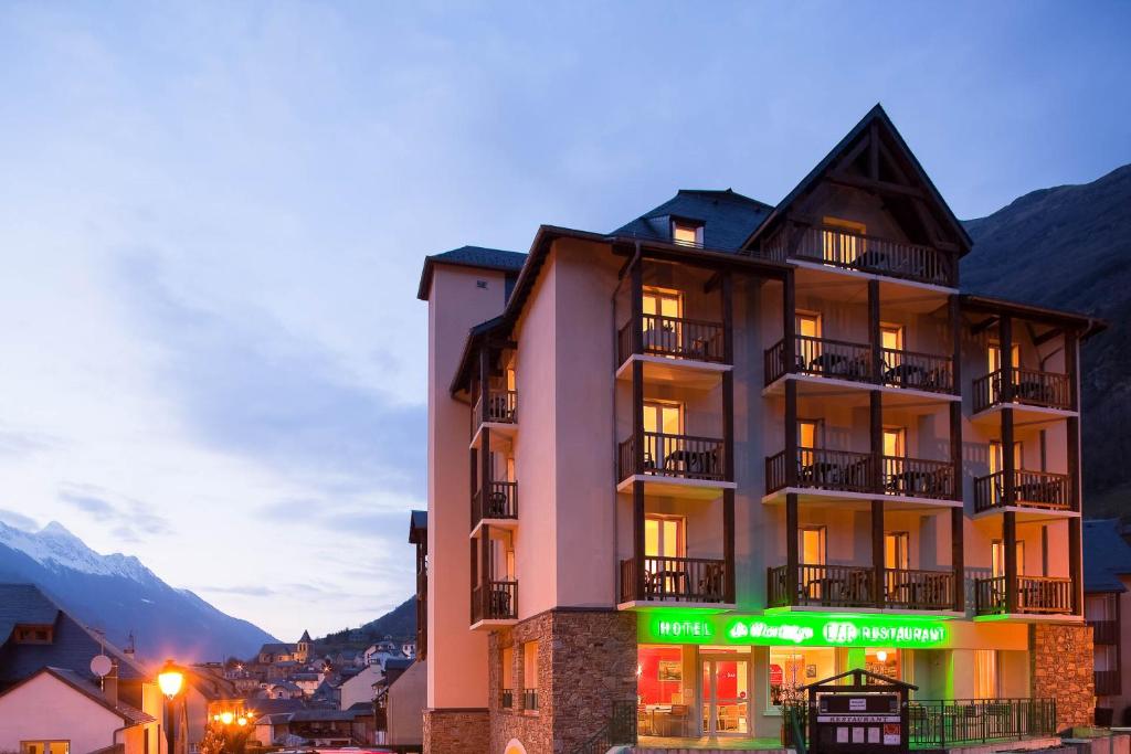 a building with a sign on the side of it at Hôtel Le Montaigu in Luz-Saint-Sauveur