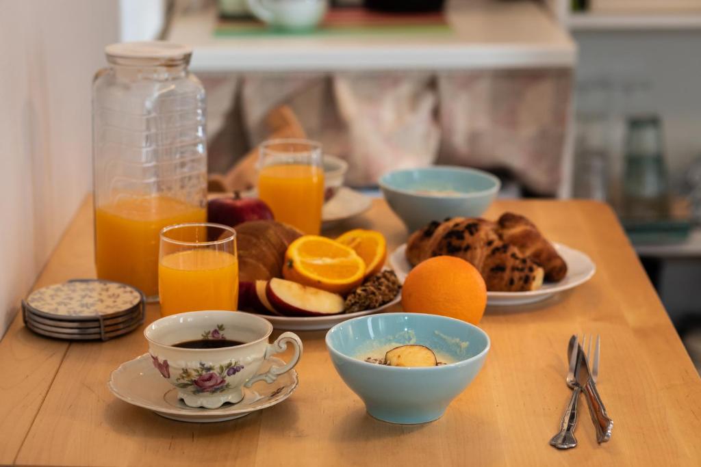 a wooden table with breakfast foods and orange juice at Guest House Blue Wave in Dubrovnik