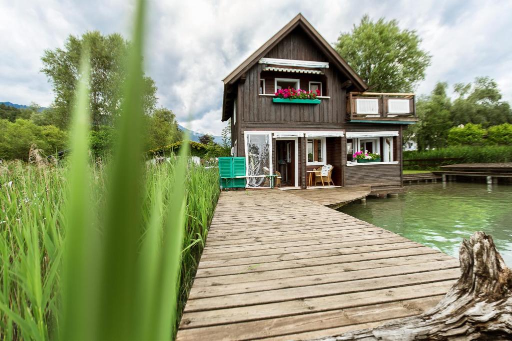 una casa su un molo vicino a un corpo d'acqua di Dietrichsteinerhof Apartments & Rooms a Faak am See