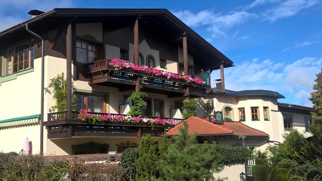 a large house with flowers on the balconies at Dietrichsteinerhof Apartments & Rooms in Faak am See