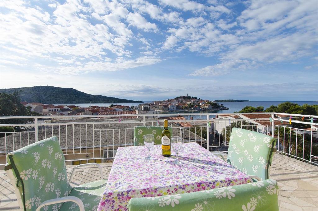 een tafel en stoelen met een fles wijn op een balkon bij Apartment Josipa in Primošten