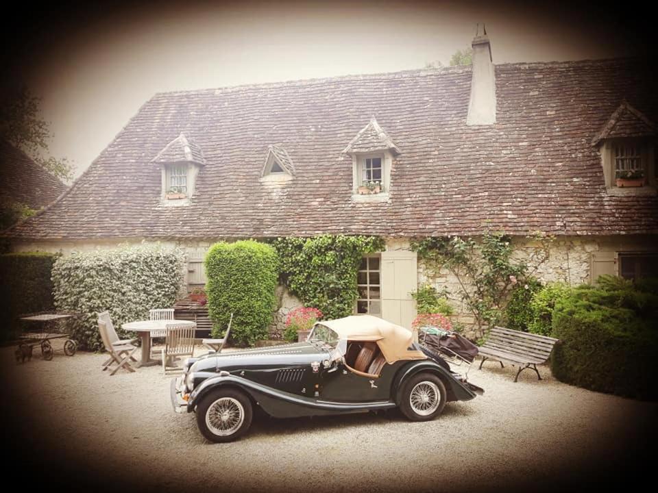 an old car parked in front of a house at Domaine du Merlot in Sainte-Sabine