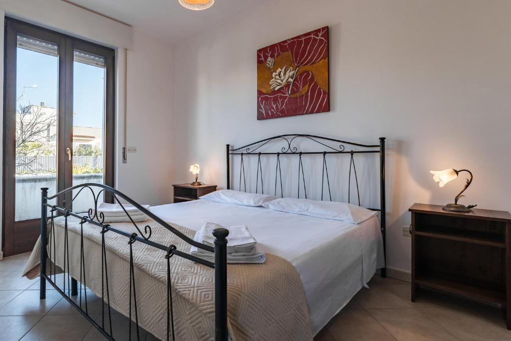 a bedroom with a large bed and a window at Keysbano Residence Pantanagianni in Carovigno
