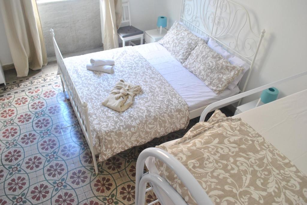 a bedroom with a bed with shoes and a chair at Sunrise Hostel & Rooms in Palermo