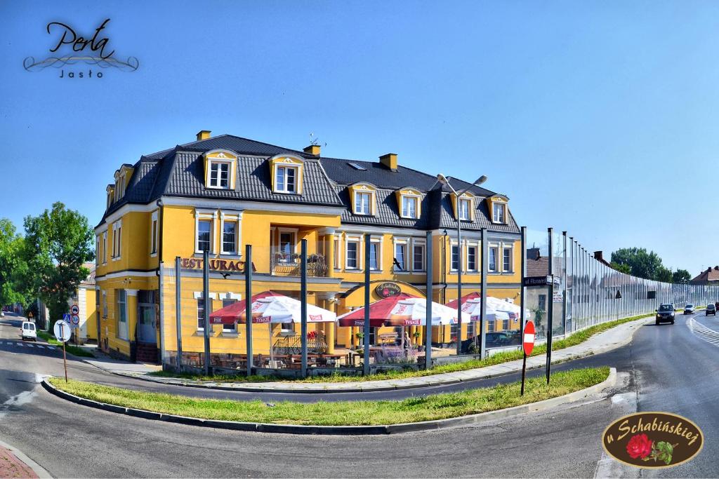 a yellow building with umbrellas in front of it at U Schabińskiej - Jedzenie i Spanie w Jaśle in Jasło