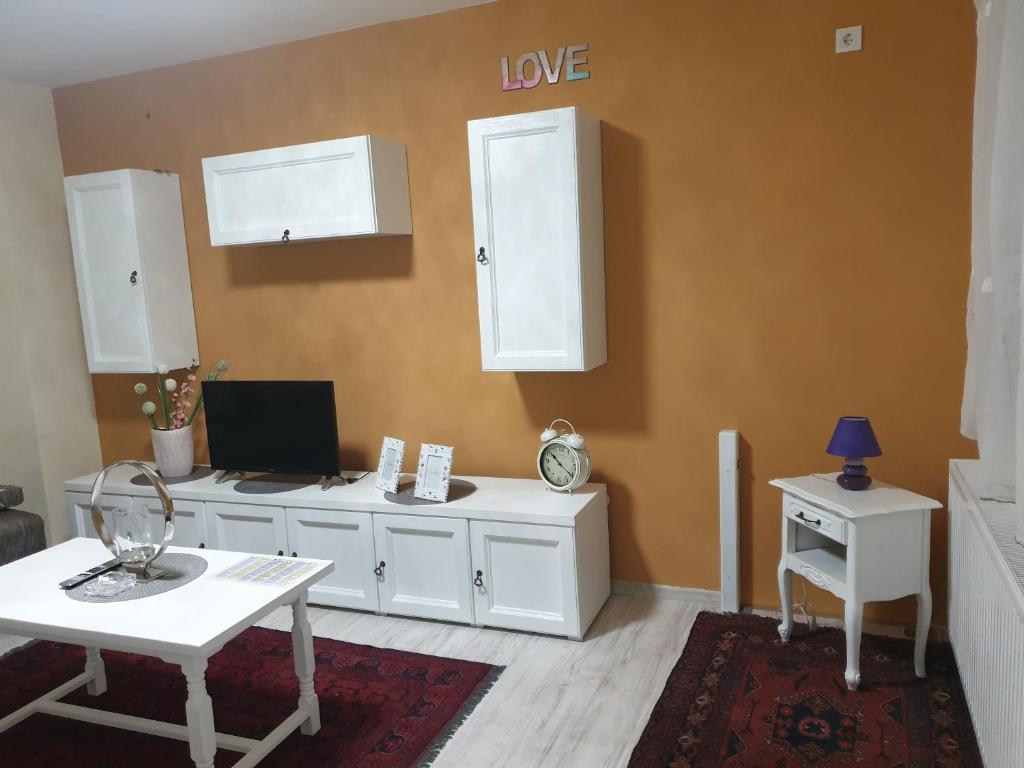 uma sala de estar com uma secretária branca e uma mesa em ivana 2 em Belišće