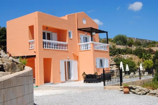 una gran casa naranja con una valla negra delante de ella en Rhodes Demetrius Luxury Private Villa, en Kalathos