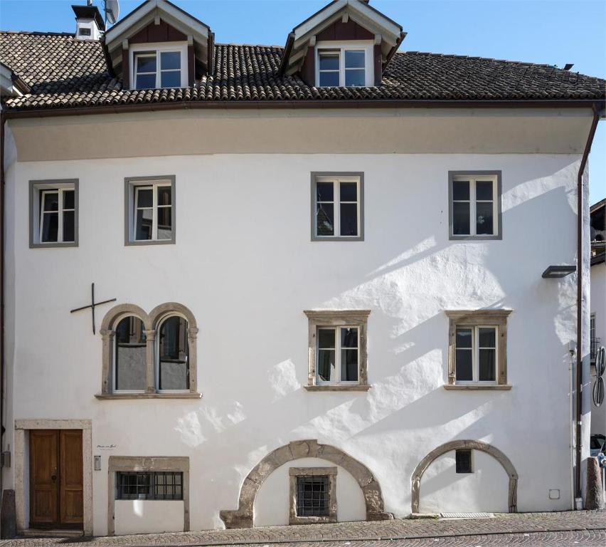 une maison blanche avec de la neige sur la façade dans l'établissement Maria von Buol - Wohnen in Kaltern, à Caldaro