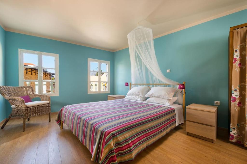 a bedroom with blue walls and a bed and a chair at Colourful Home, Medieval Town Rhodes in Rhodes Town