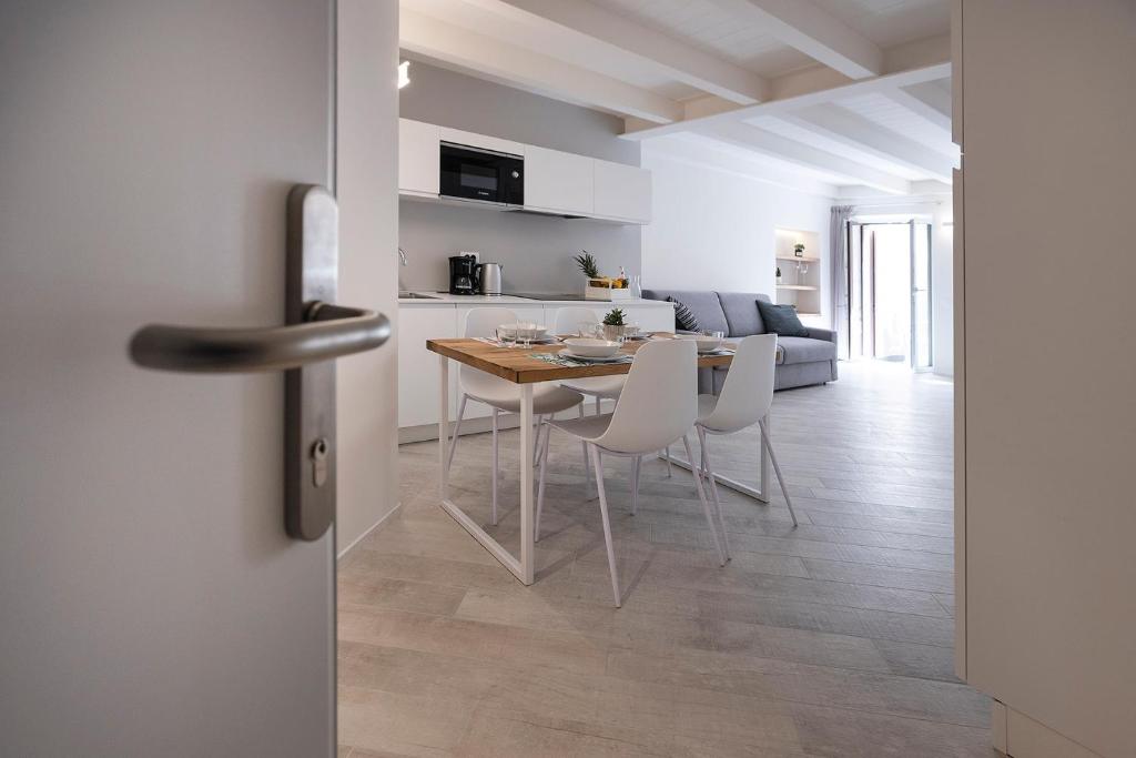 cocina y sala de estar con mesa y sillas en Picalof Apartments en Malcesine