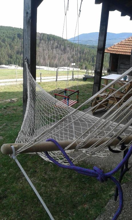 a hammock hanging from a pole in a park at Planinarski dom "Tornik" Zlatibor in Ribnica