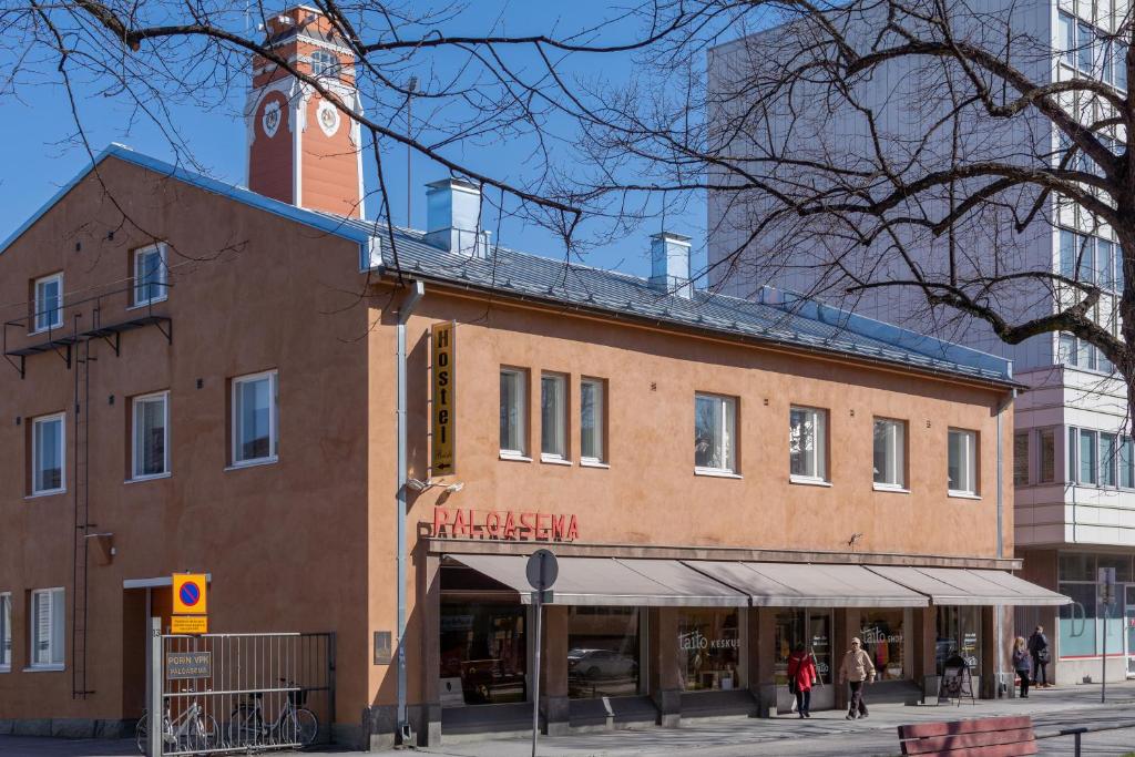 un grand bâtiment en briques avec une tour d'horloge en haut dans l'établissement Hostel Buisto, à Pori