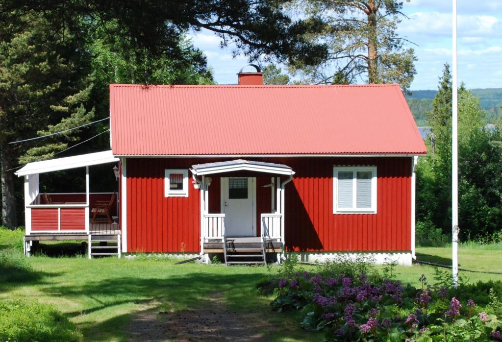 uma casa rústica vermelha com um telhado vermelho em Backnäsgården em Sandöverken