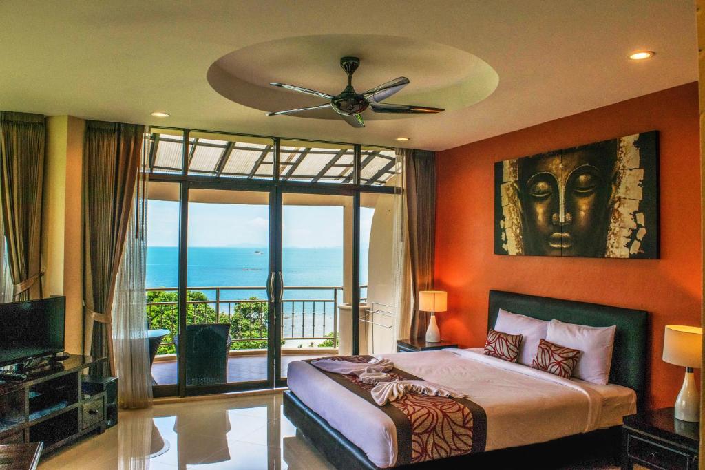 a bedroom with a bed and a view of the ocean at Sunset Hill Boutique Resort Koh Phangan in Haad Chao Phao