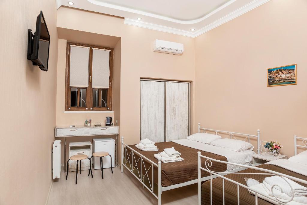a bedroom with a bed and a desk and a sink at HOME 6 in Tbilisi City