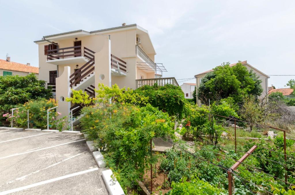 een huis met veel planten ervoor bij Apartment Damir in Primošten