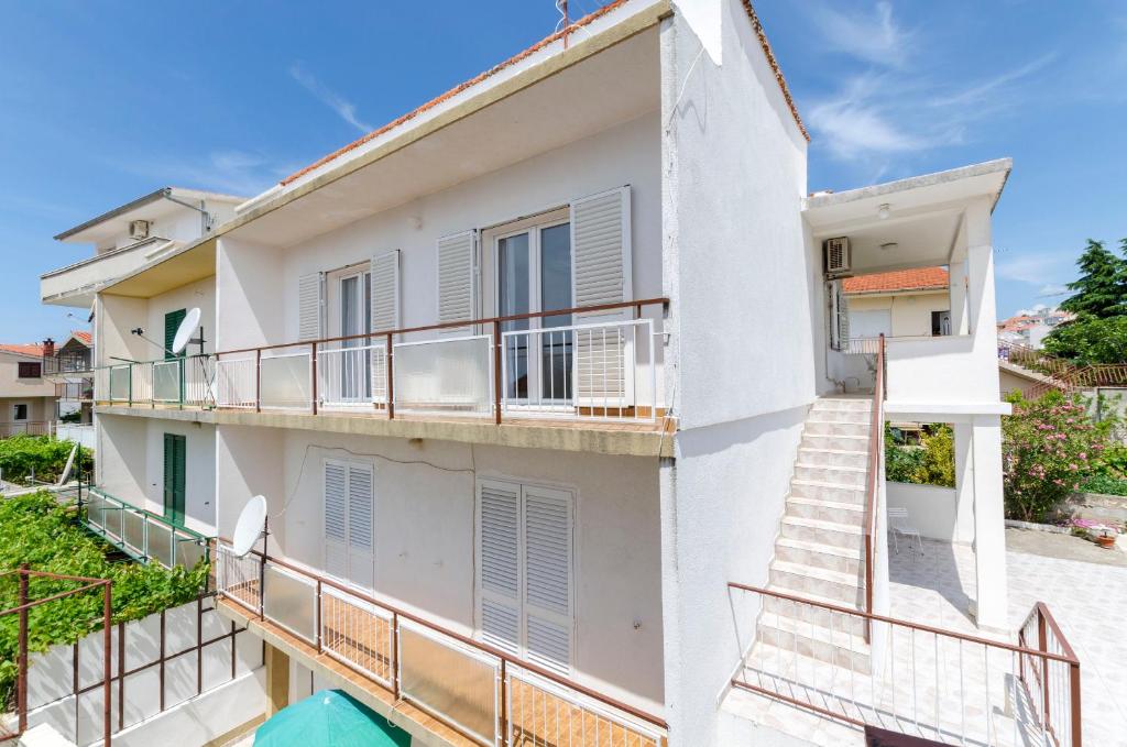 a building with balconies and stairs in front of it at Apartments Visnja in Primošten