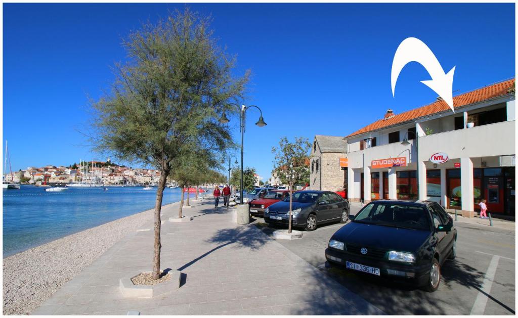 een auto geparkeerd op een stoep naast een boom bij Apartment Slavko in Primošten