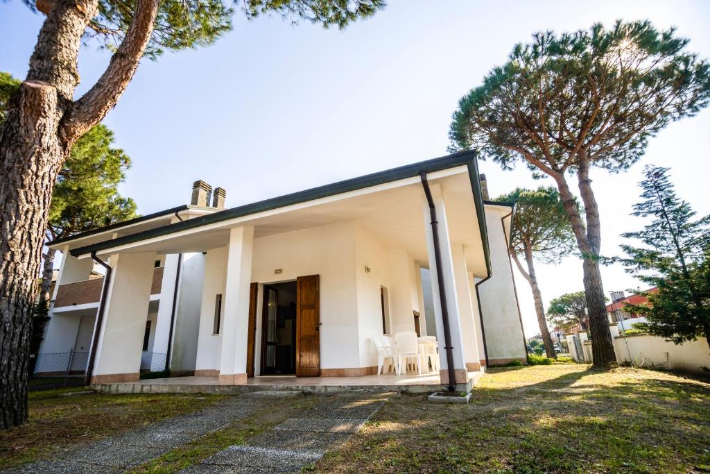 una casa con una grande porta a vetri e alberi di Agenzia Vear - Lido di Volano a Lido di Volano