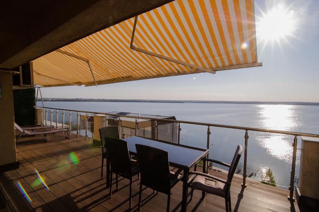 a balcony with a table and chairs and a view of the water at Sea Gem Mamaia - 200m to Beach, XL Terrace, and Beautiful Views in Mamaia