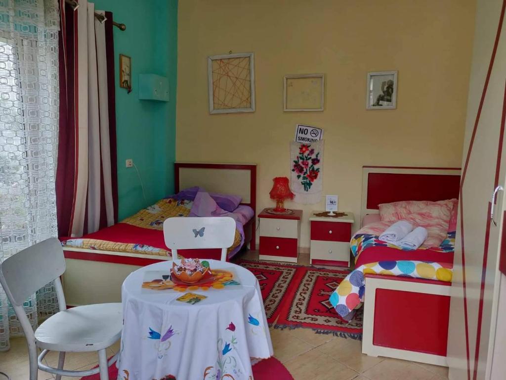 Cette petite chambre comprend deux lits, une table et des chaises. dans l'établissement Private room historic center Elbasan, à Elbasan