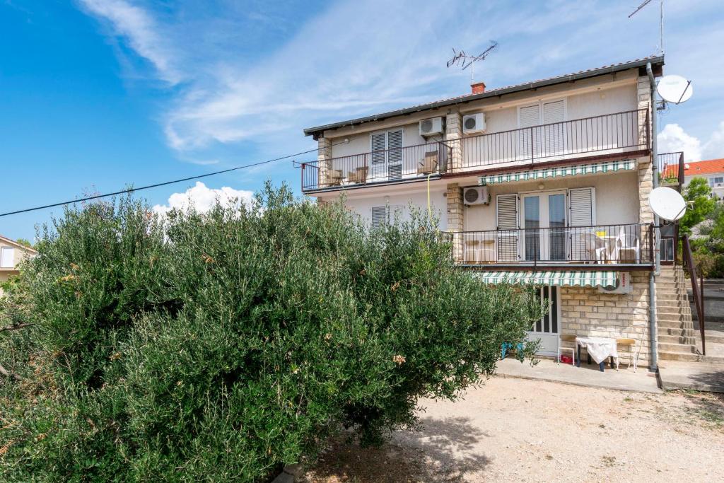 an apartment building with a bush in front of it at Apartment Palcic in Primošten