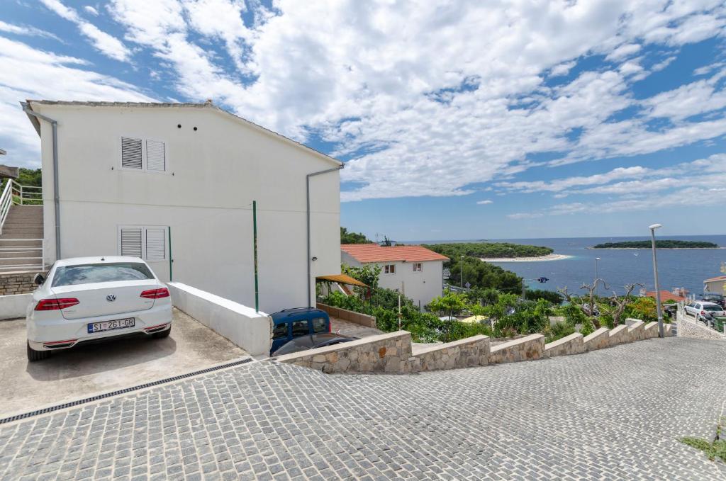 a white car parked next to a white building at Apartments and Room Mate-Mare in Primošten