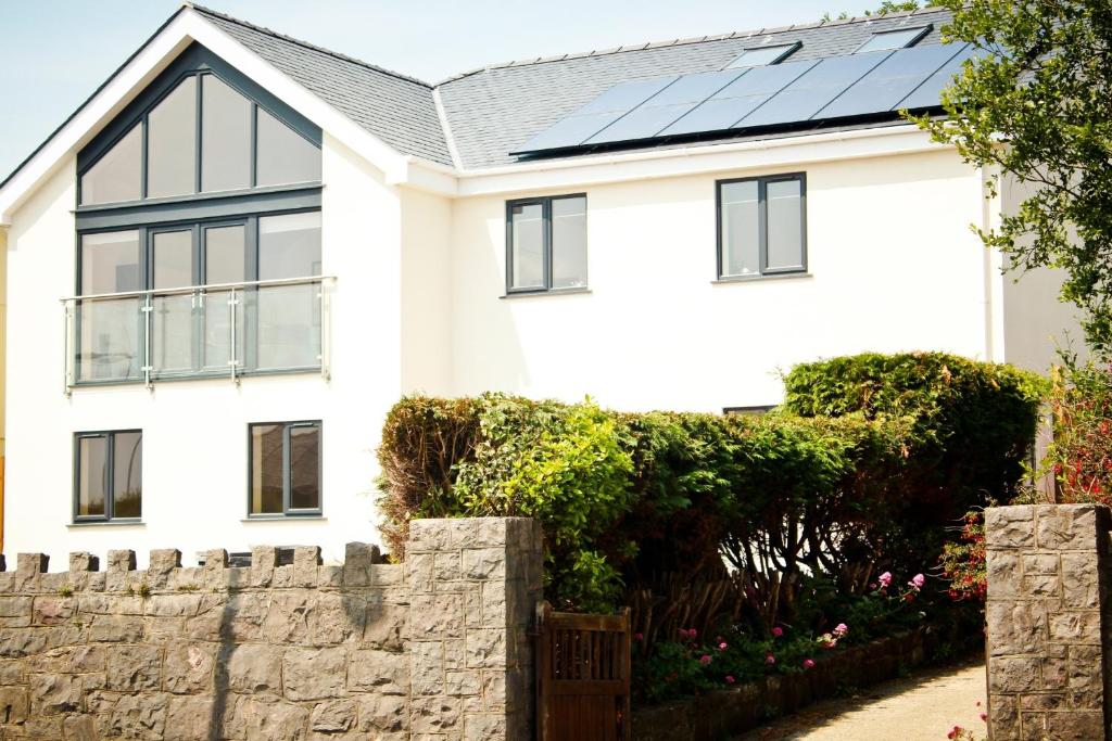 a white house with solar panels on the roof at Lux Apartment in Bangor