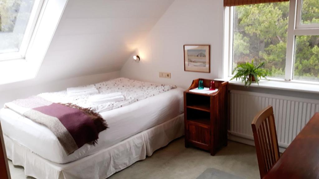 Schlafzimmer mit einem Bett, einem Tisch und Fenstern in der Unterkunft Úlfarsfellsvegur 20, 113 Rvk Birkihlid in Reykjavík