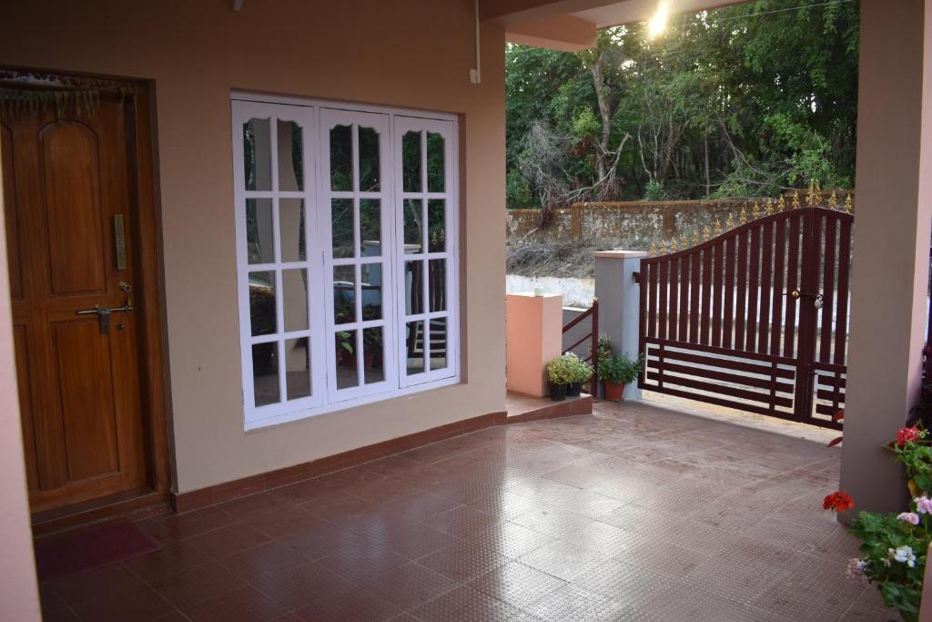 a patio with a white door and a staircase at Srishti Homestay in Madikeri