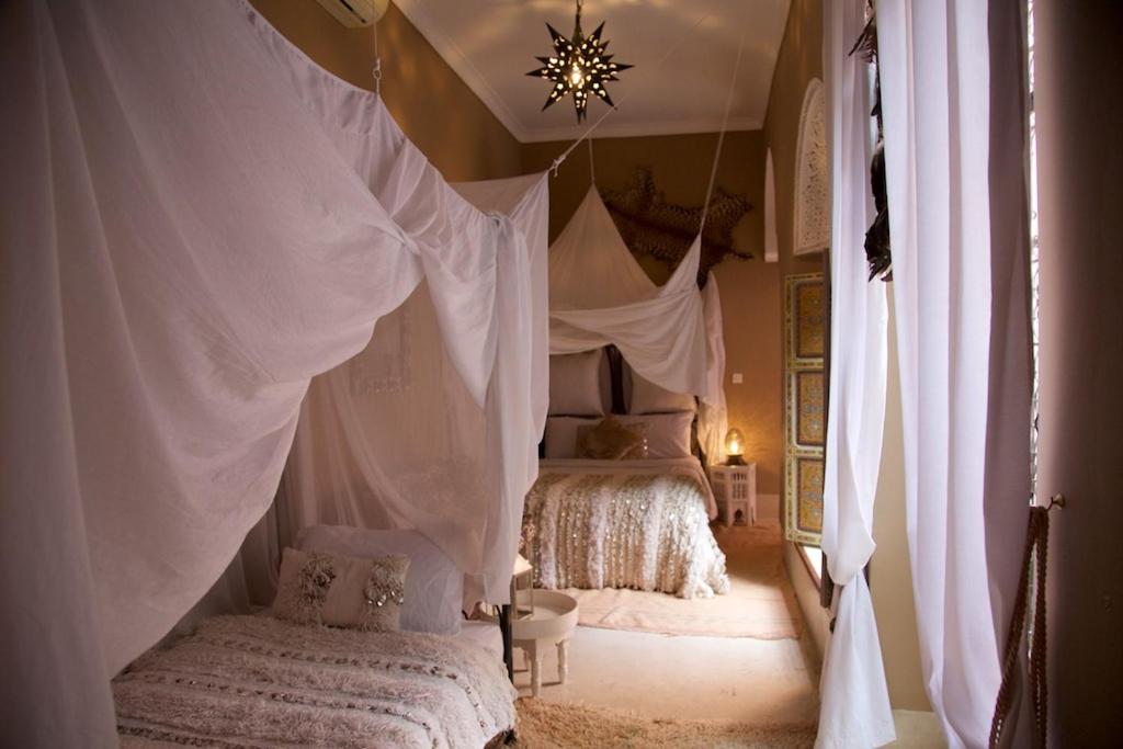 - une chambre avec 2 lits dotés de rideaux blancs dans l'établissement The Bohemian Jungle, à Marrakech