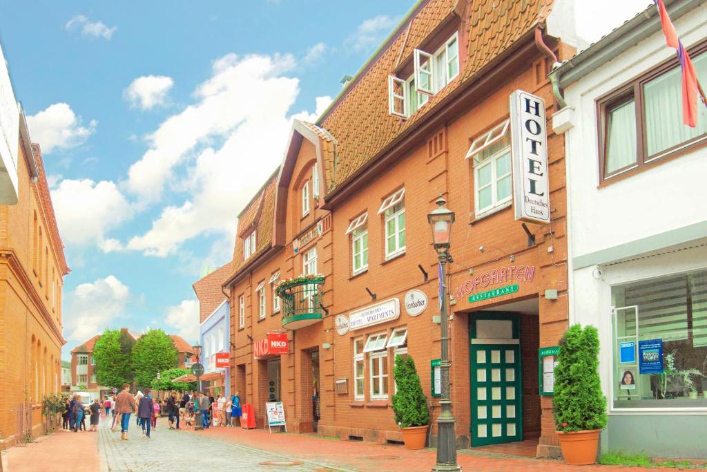 a group of people walking down a street in a town at Hotel Deutsches Haus in Heiligenhafen