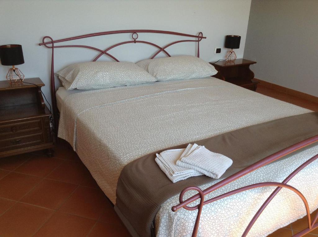 ein Schlafzimmer mit einem großen Bett mit zwei Nachttischen in der Unterkunft Casa Gabri, comodo appartamento in centro storico e vicino al mare in Formia