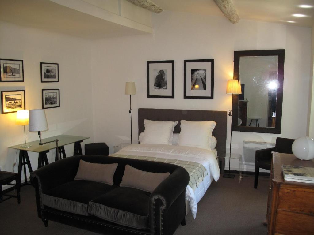 1 dormitorio con cama, sofá y espejo en Appartement Cours Mirabeau CrsMb, en Aix-en-Provence