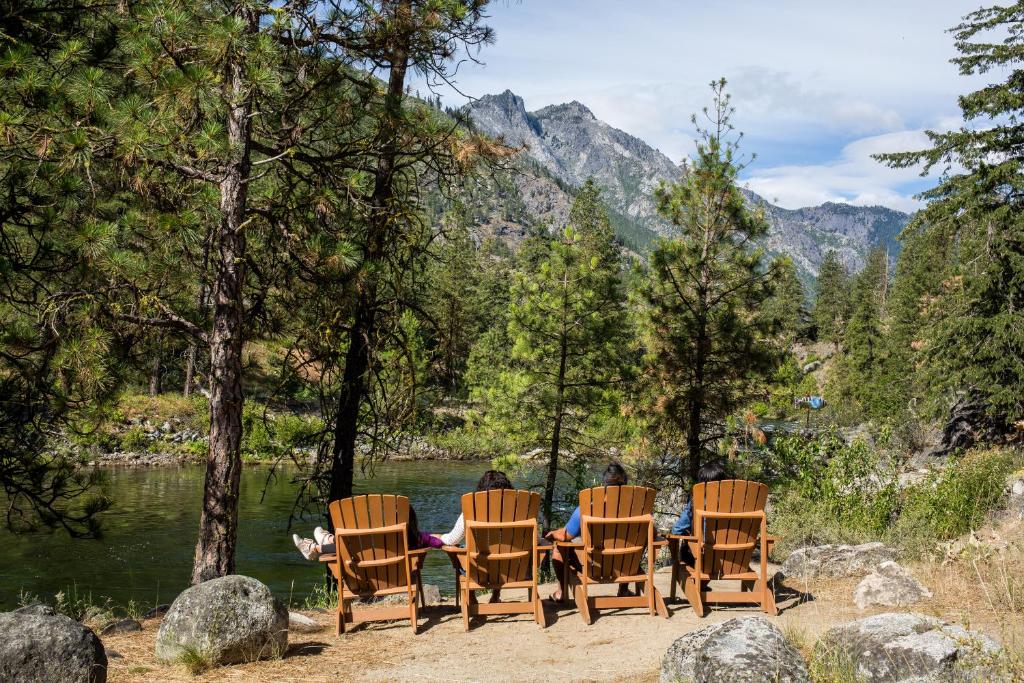 a group of people sitting around a table by a river at Sleeping Lady Mountain Resort in Leavenworth