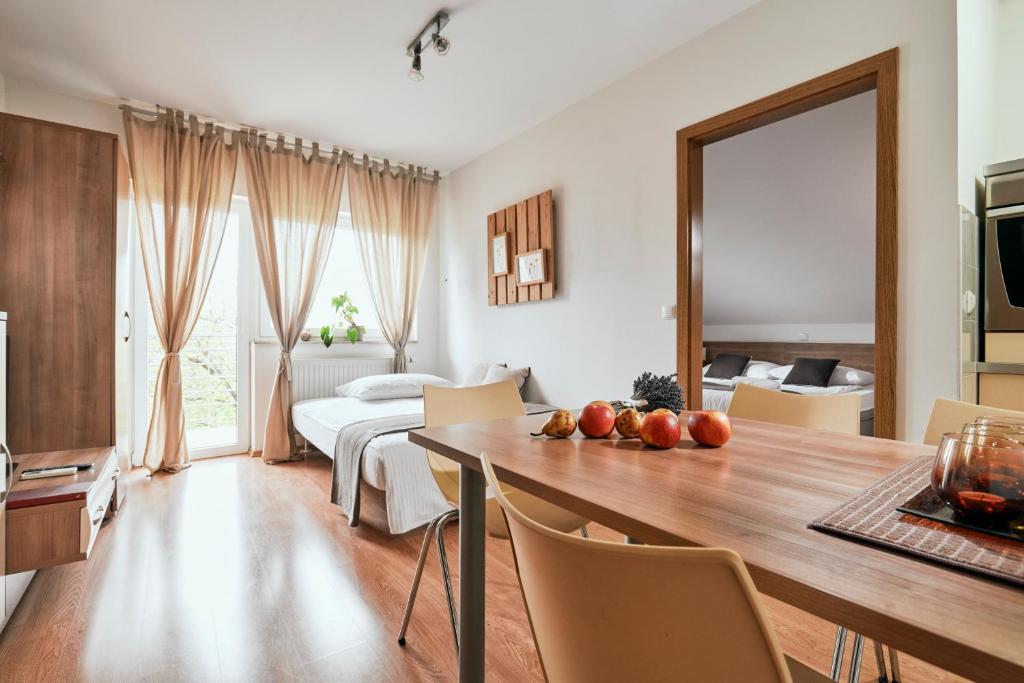 ein Wohnzimmer mit einem Esstisch und ein Schlafzimmer in der Unterkunft Ostarija Herbelier in Dolenjske Toplice