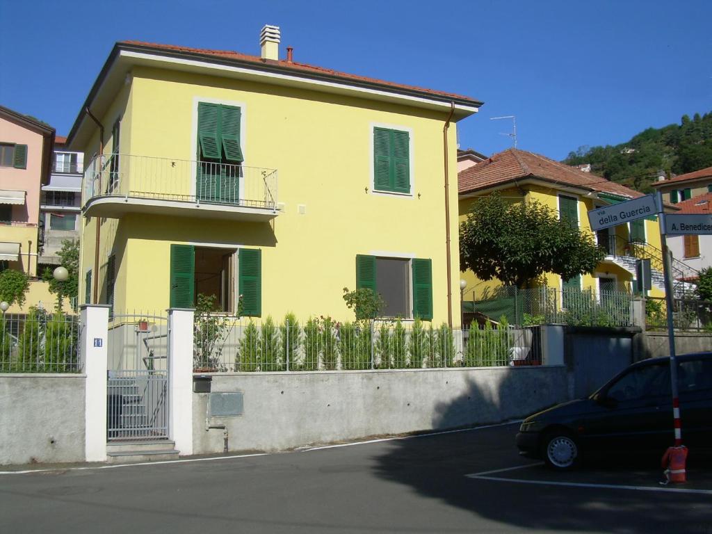 una casa amarilla con una valla delante de ella en La Casa Delle Rose, en La Spezia