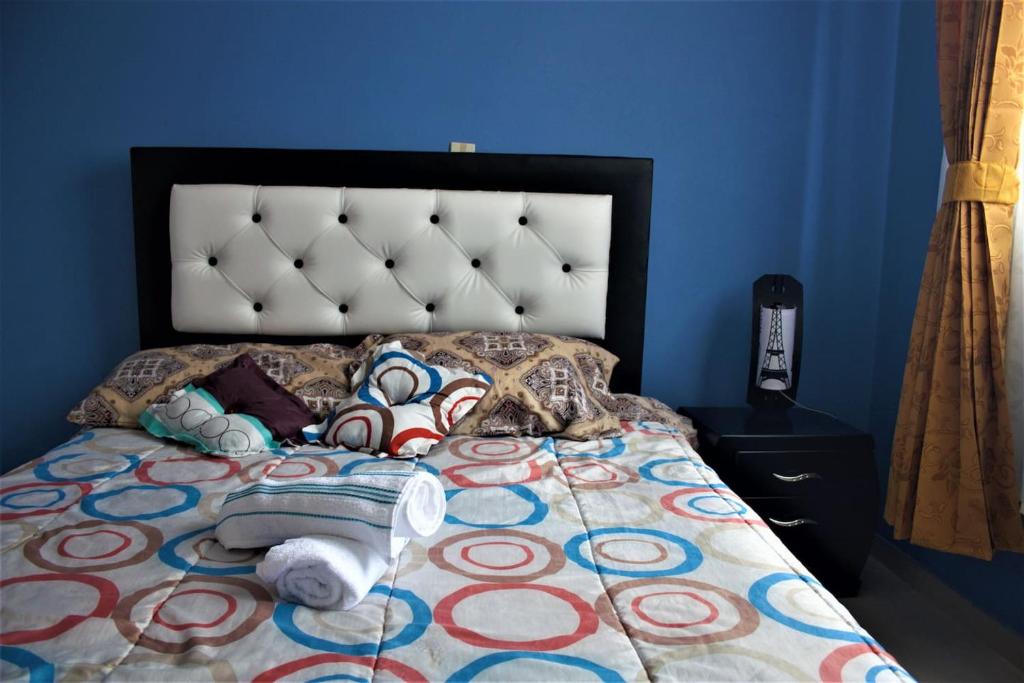 um quarto com uma cama com uma parede azul em Casa de alquiler Killa Wasi, Paipa em Paipa