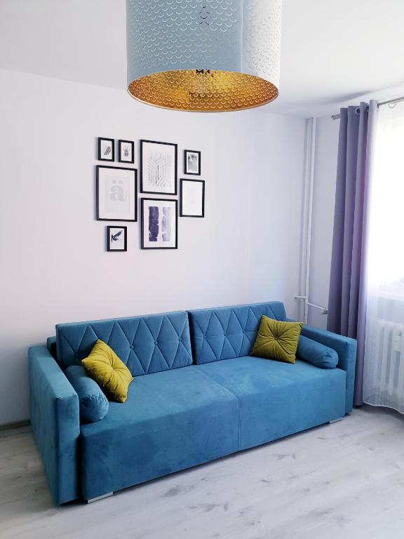 a blue couch with yellow pillows in a living room at Apartament Wałbrzych in Wałbrzych